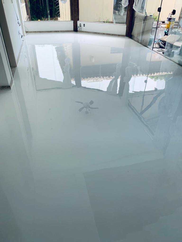 Piso epóxi branco com acabamento brilhante em área interna ampla