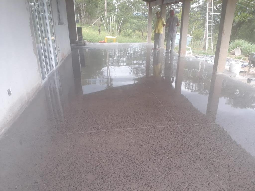 Estacionamento coberto com piso epóxi cinza e demarcação amarela de vagas e circulação
