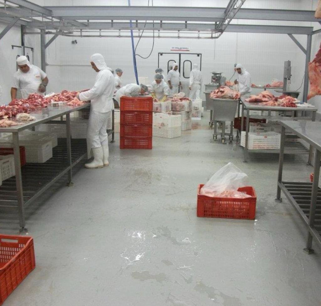 Piso industrial cinza com demarcação amarela em área logística de grande circulação